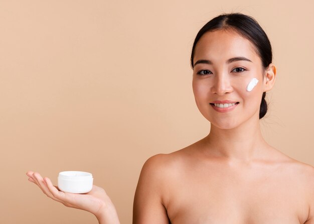 Primer plano mujer morena con crema para la cara