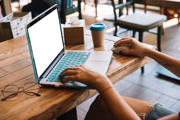 Primer plano de mujer navegando en la computadora portátil en el restaurante