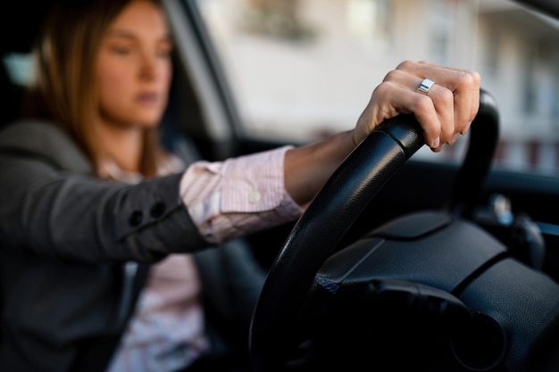 Primer plano de una mujer de negocios detrás del volante de un automóvil que viaja al trabajo