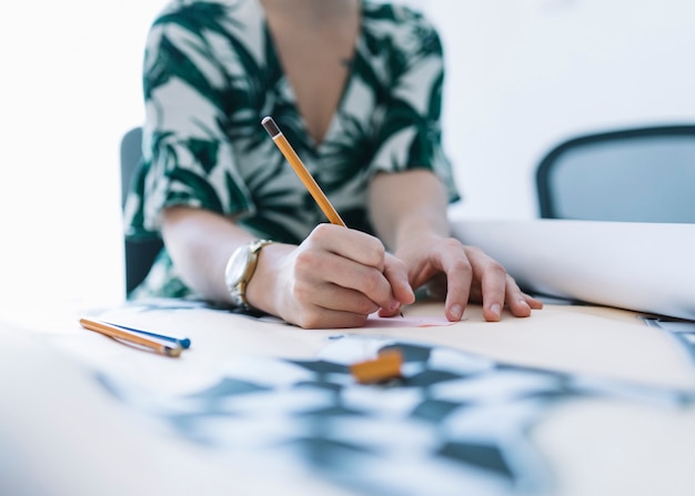 Foto gratuita primer plano, de, un, mujer de negocios, dibujo, en, gráfico, con, lápiz