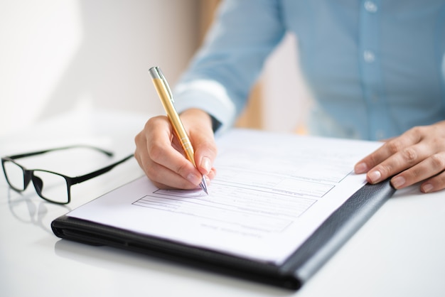 Foto gratuita primer plano de mujer de negocios haciendo notas en el documento