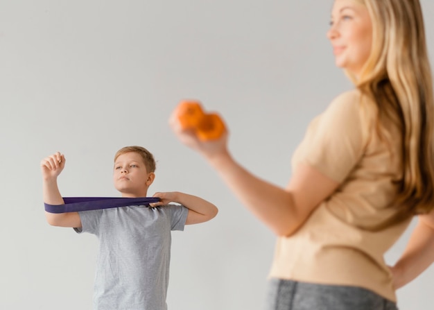 Foto gratuita primer plano mujer y niño haciendo ejercicio