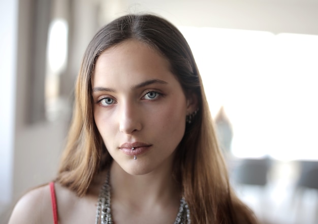 Primer plano de una mujer con una pared blanca como fondo