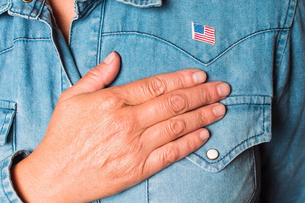 Primer plano de una mujer patriótica con la mano en el corazón