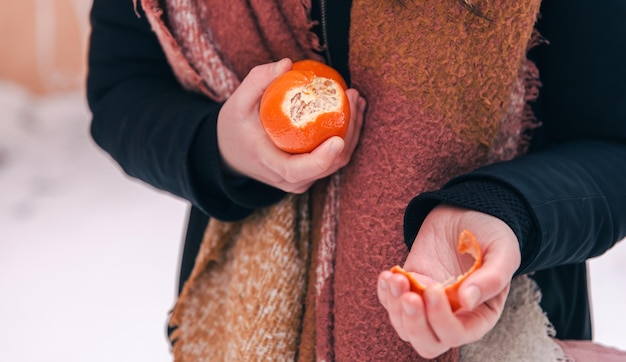 Primer plano una mujer pela un fondo borroso de mandarina