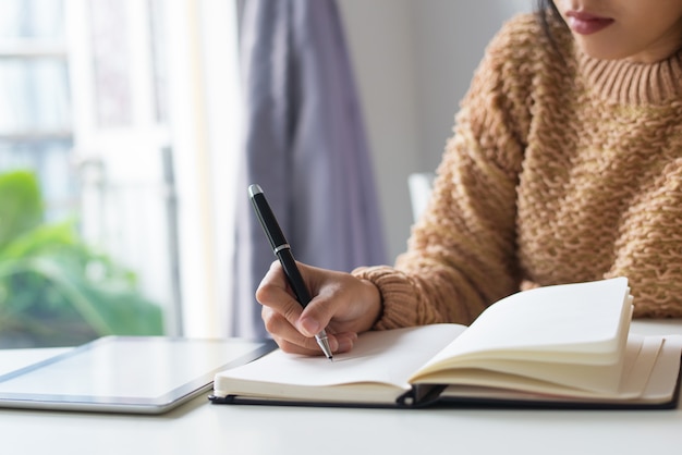 Foto gratuita primer plano de la mujer pensativa escribir ideas en el diario