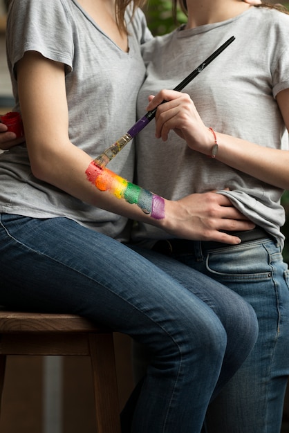 Foto gratuita primer plano de mujer pintando bandera lbgt en la mano de su novia con pincel