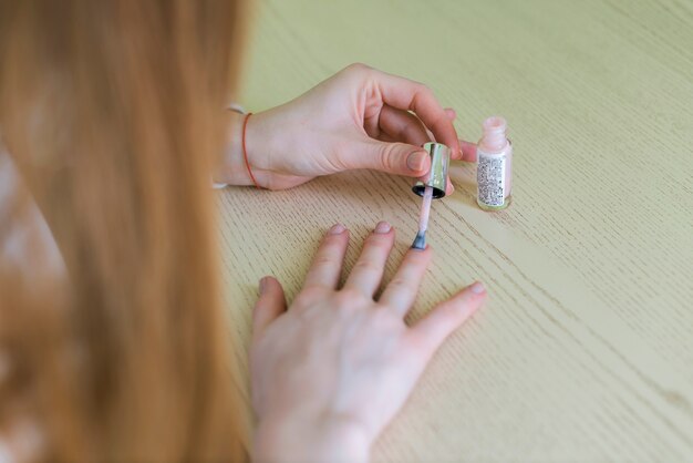 Primer plano de mujer pintándose las uñas