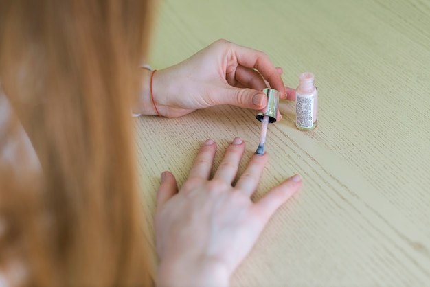 Primer plano de mujer pintándose las uñas
