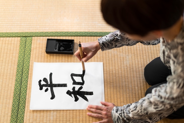 Primer plano mujer pintura letra japonesa