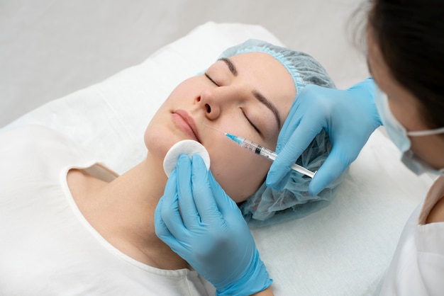 Primer plano de la mujer durante el procedimiento de relleno de labios