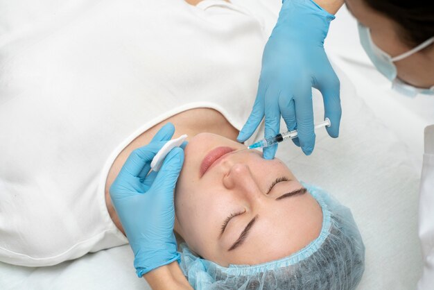 Primer plano de la mujer durante el procedimiento de relleno de labios