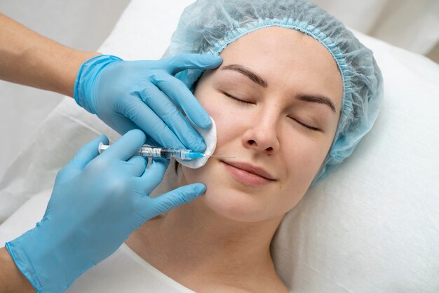 Primer plano de la mujer durante el procedimiento de relleno de labios