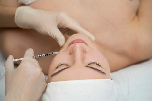 Primer plano de la mujer durante el procedimiento de relleno de labios