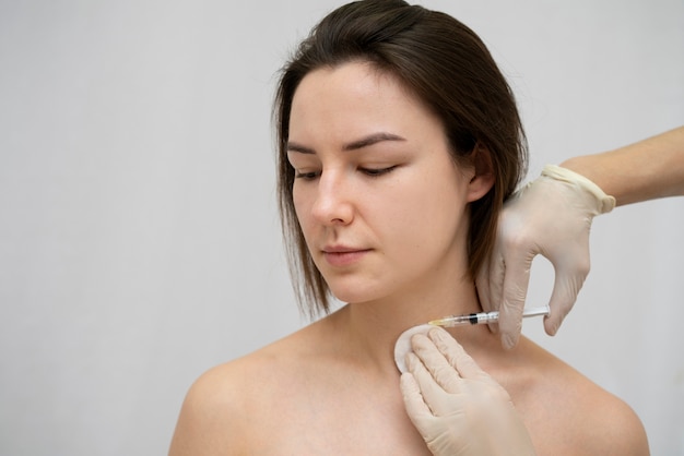 Primer plano de la mujer durante el procedimiento de relleno de labios