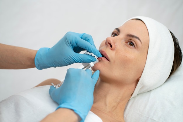 Primer plano de la mujer durante el procedimiento de relleno de labios