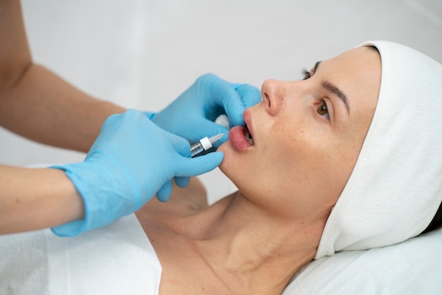 Primer plano de la mujer durante el procedimiento de relleno de labios