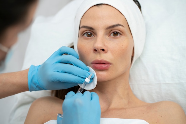 Primer plano de la mujer durante el procedimiento de relleno de labios