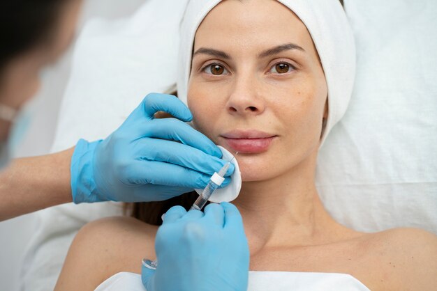 Primer plano de la mujer durante el procedimiento de relleno de labios