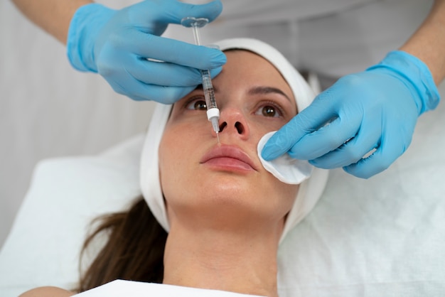 Primer plano de la mujer durante el procedimiento de relleno de labios