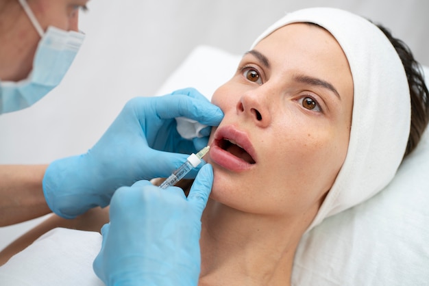 Primer plano de la mujer durante el procedimiento de relleno de labios