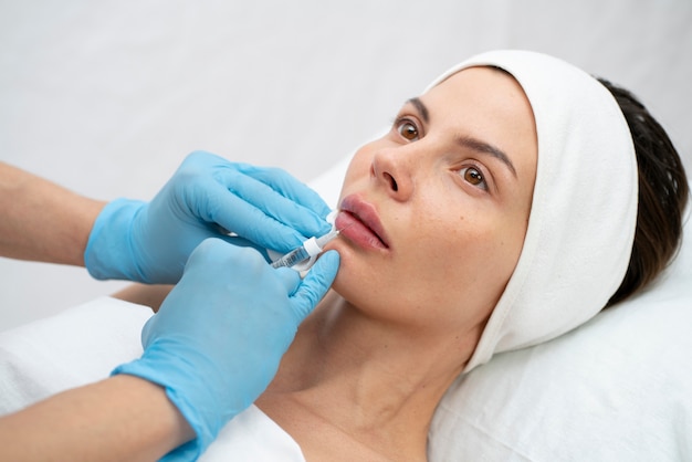 Primer plano de la mujer durante el procedimiento de relleno de labios