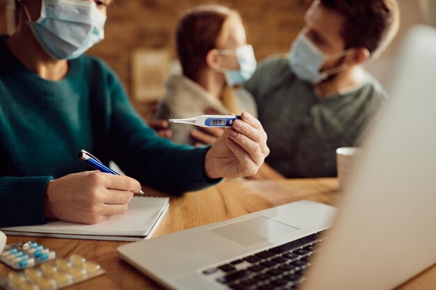 Primer plano de una mujer que consulta con un médico sobre la fiebre de su hija a través de una videollamada