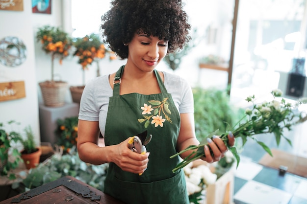 Primer plano, de, un, mujer que sostiene, tijeras de podar, y, ramo de flores