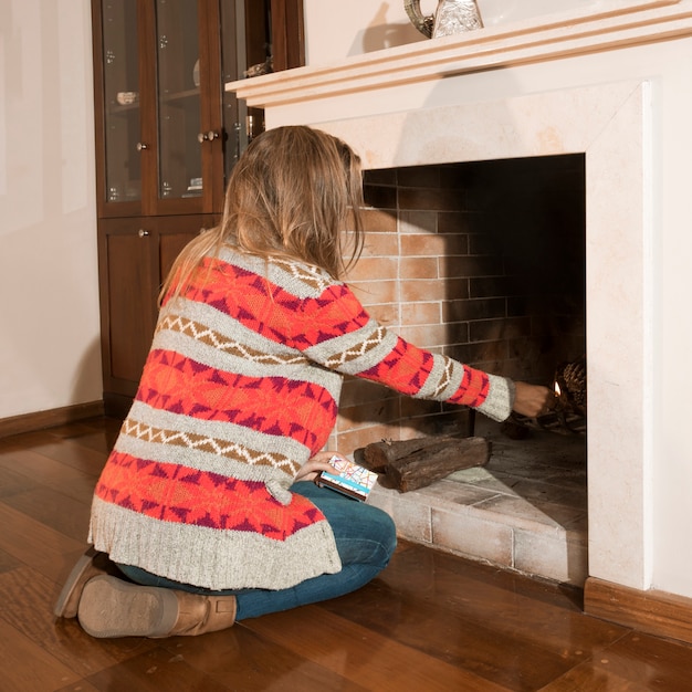 Foto gratuita primer plano de mujer quema fuego en la chimenea en casa