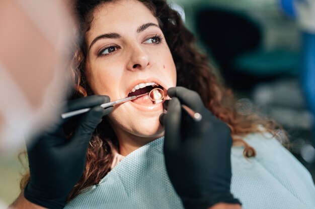 Primer plano de mujer recibiendo un chequeo en el dentista