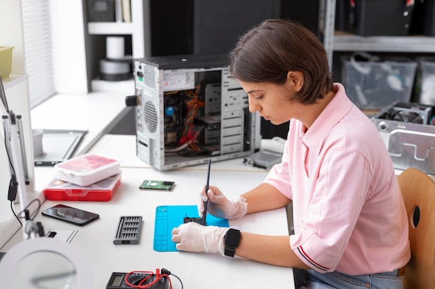 Primer plano de una mujer reparando chips de computadora