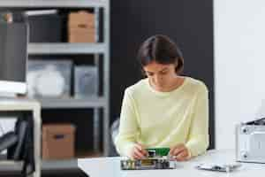 Foto gratuita primer plano de una mujer reparando chips de computadora