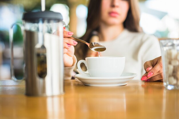 Primer plano de una mujer revolviendo té con cuchara