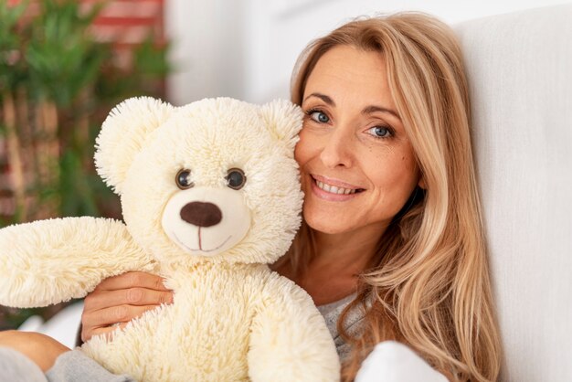 Primer plano mujer rubia con oso de peluche