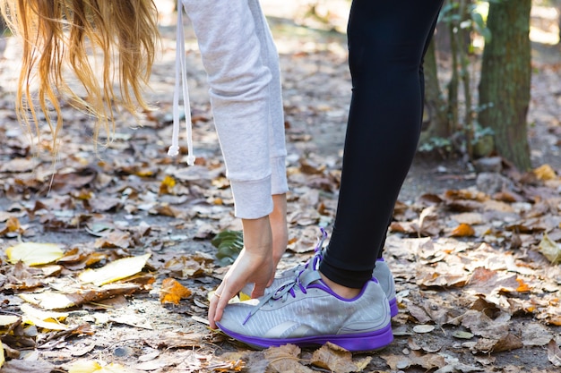 Foto gratuita primer plano de mujer rubia de pie mientras se toca los pies con las manos