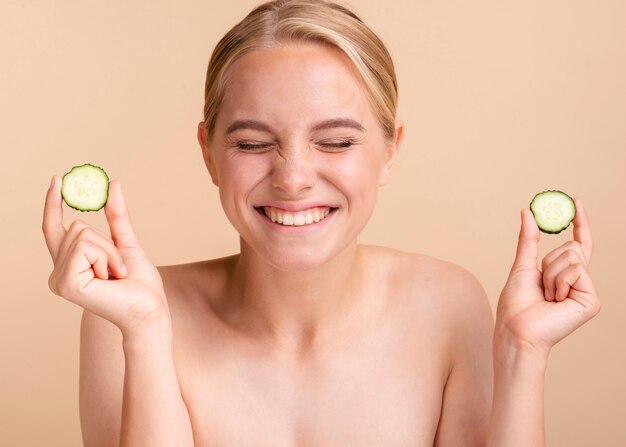 Primer plano mujer rubia con rodajas de pepino