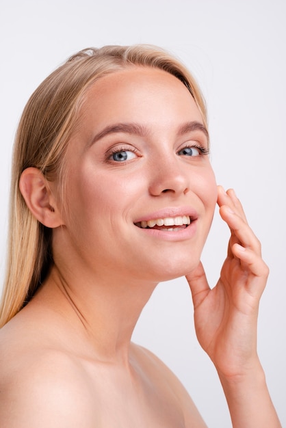 Primer plano mujer rubia sonriendo con fondo blanco