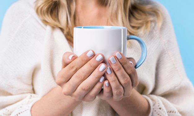 Primer plano mujer rubia sosteniendo una taza