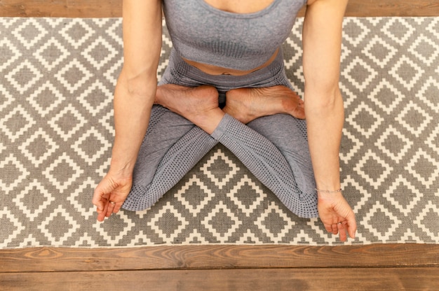 Foto gratuita primer plano mujer sentada en la estera de yoga