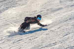 Foto gratuita primer plano de una mujer snowboarder en movimiento sobre una tabla de snowboard en una montaña