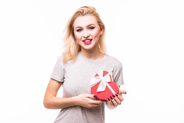 Primer plano de mujer sonriente con caja de regalo en forma de corazón rojo