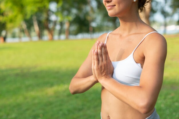 Primer plano mujer sonriente meditando pose de brazo