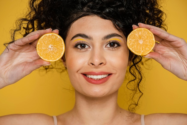 Foto gratuita primer plano mujer sonriente sosteniendo rodajas de limón