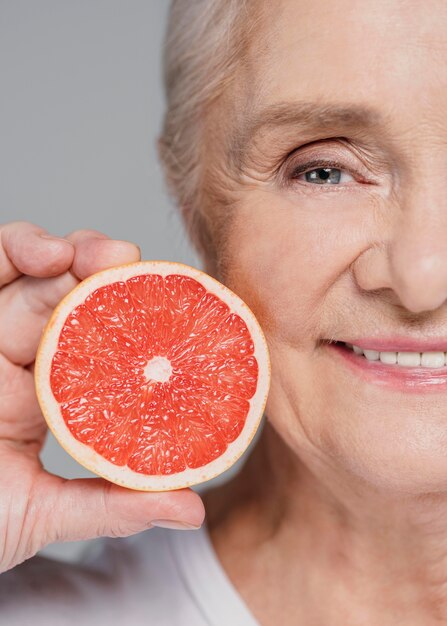 Primer plano mujer sonriente sosteniendo rojo naranja