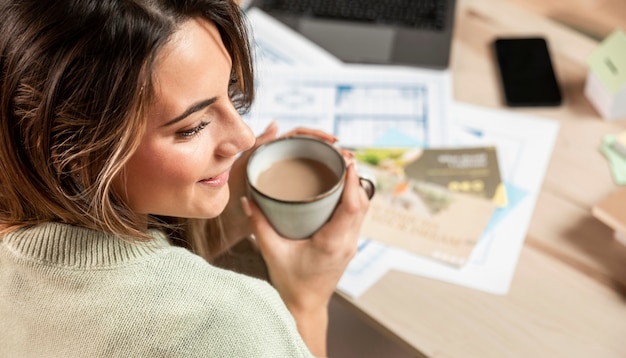 Primer plano mujer sonriente sosteniendo la taza de café