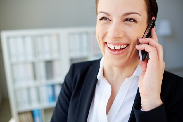 Primer plano de mujer sonriente con el teléfono móvil