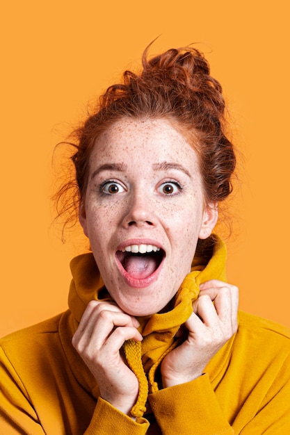 Primer plano mujer sorprendida con fondo naranja