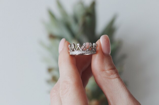 Primer plano de una mujer sosteniendo un anillo en forma de corona