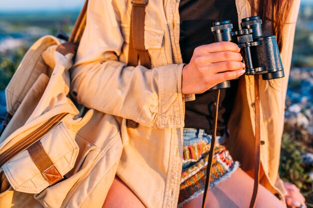 Primer plano de una mujer sosteniendo binocular