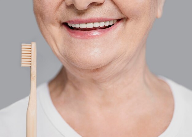 Primer plano mujer sosteniendo cepillo de dientes